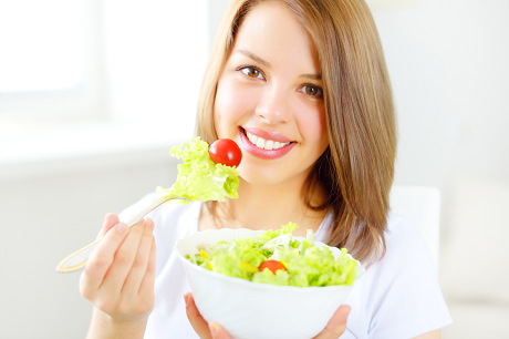 Adolescente qui mange de la salade