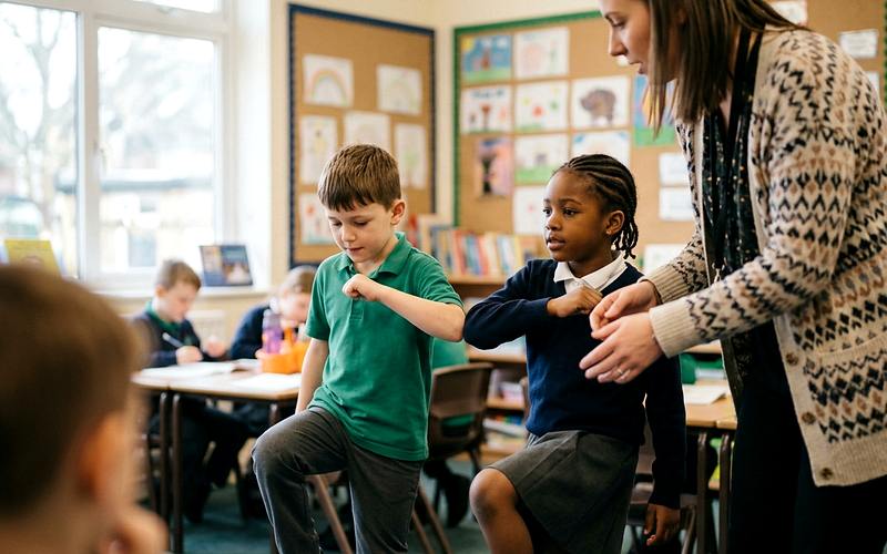 Enfants r&eacute;alisant des mouvements crois&eacute;s de Brain Gym dans une salle lumineuse