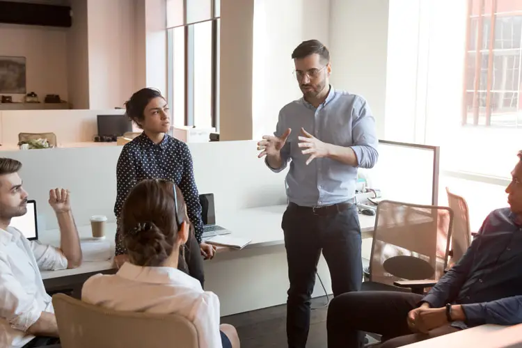 Coach en entreprise parle à divers hommes d'affaires lors d'une réunion