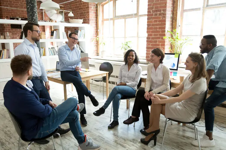 Coach riant de la blague des employés lors d'un briefingCoach riant de la blague des employés lors d'un briefing