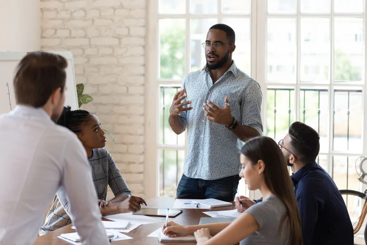 Un coach professionnel parle à divers membres du personnel lors d'une réunion
