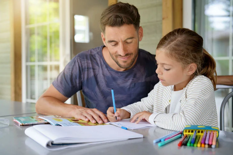 Papa avec une petite fille faisant ses devoirs