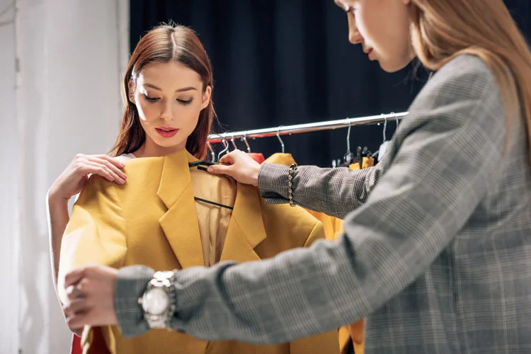 Focus sélectif d'un styliste tenant une veste jaune près du modèle