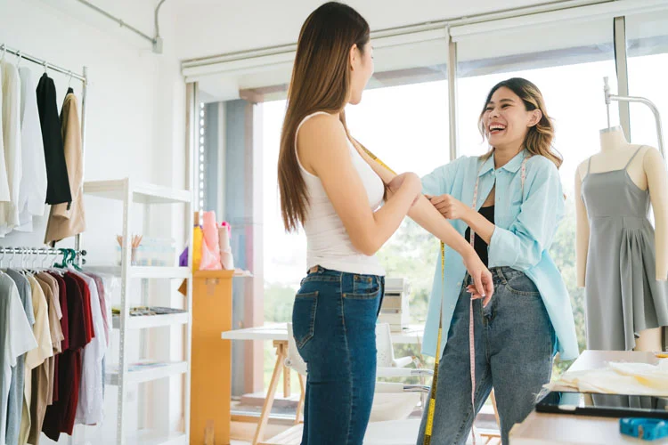 Une couturière asiatique mesure le corps de ses clients pour confectionner de nouveaux vêtements.