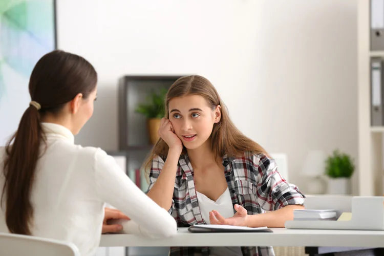 Jeune femme psychologue travaillant avec une adolescente dans un bureau