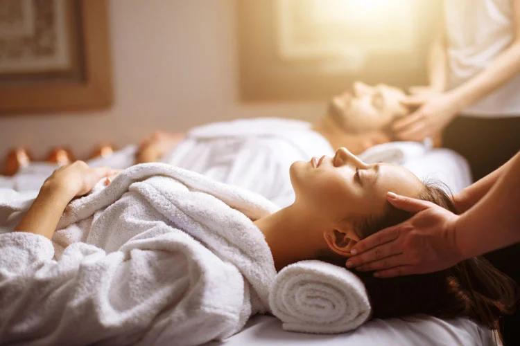 jeune et beau couple heureux profitant d'un massage de la tête au spa