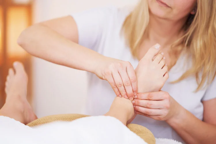 Femme se faisant masser les pieds dans un salon de réflexologie